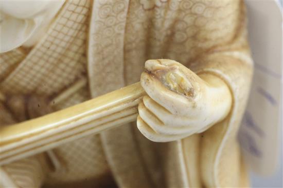 A Japanese ivory okimono of a kneeling musician, early 20th century, height 9.3cm, wood stand, damage to shamisen